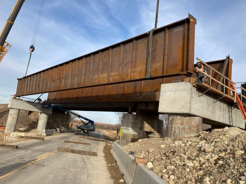 Photo is taken during setting of girders on New Bridge over Historic Scenic byway along the BNSF Transcon.  These DPG spans were set with two cranes working in very tight confines with tracks on one side and a creek on the other.