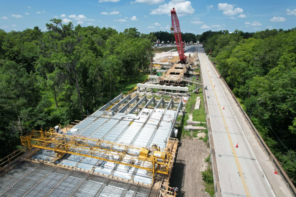 A large crane deconstructs the old bridge.
