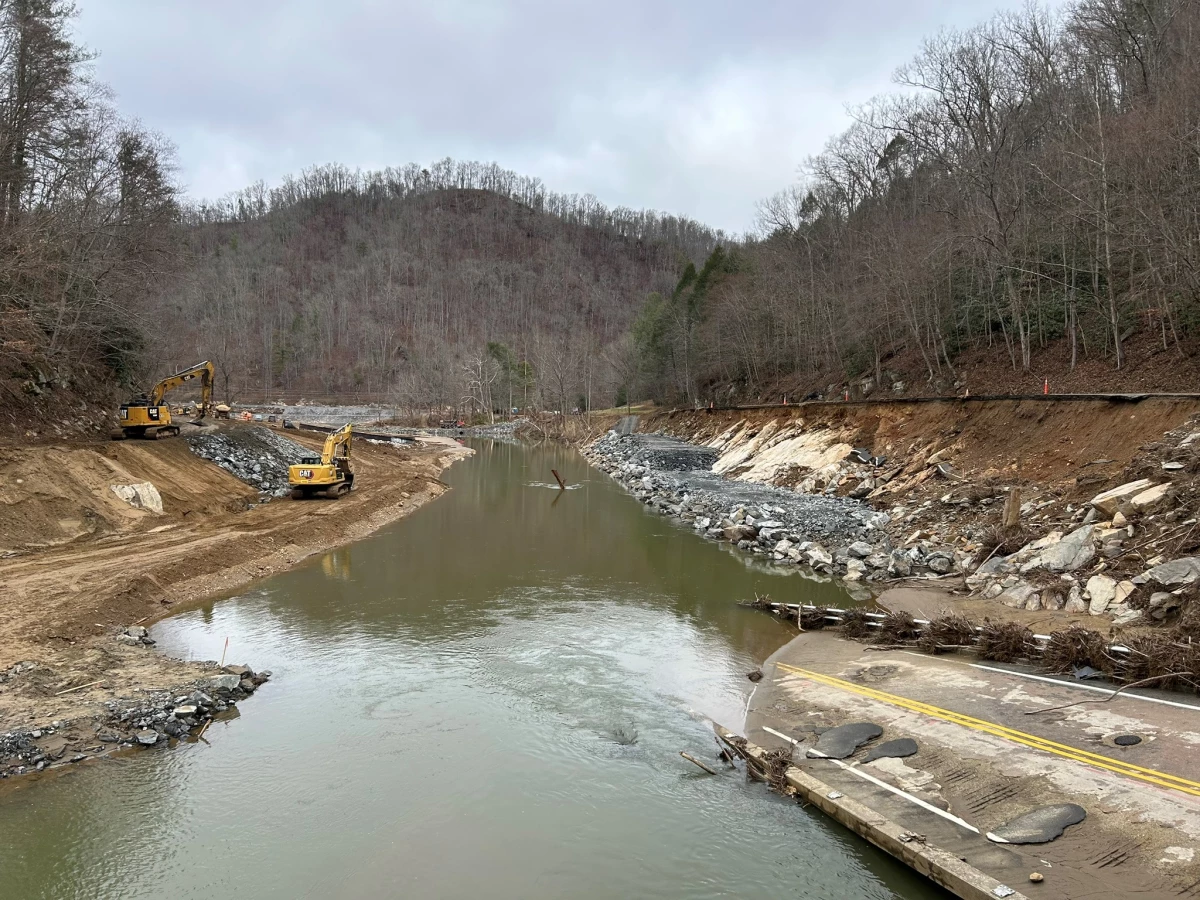 Flooded river and damaged roadway following Hurricane Helene.