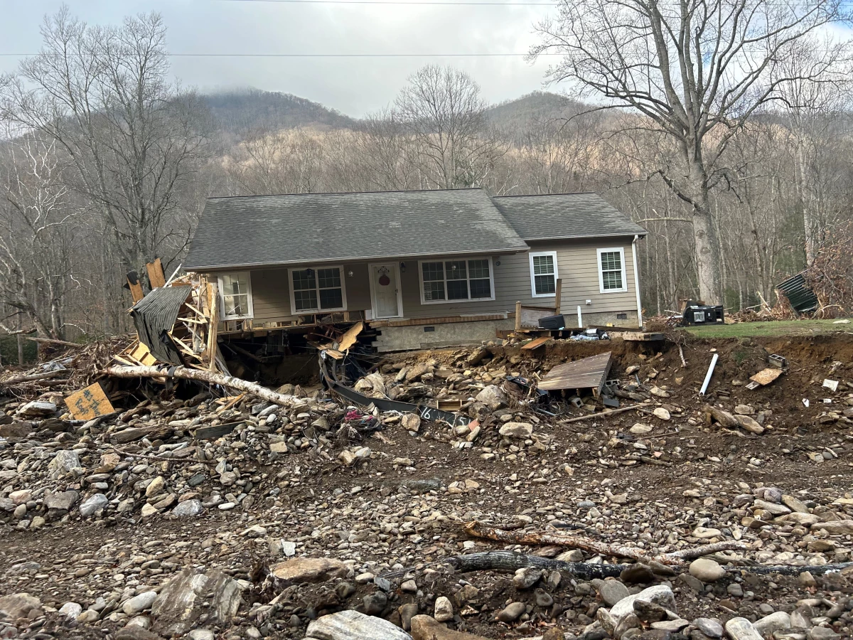 A house sits along a flooded river bank in the aftermath of Hurricane Helene.